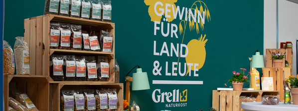 KI generiert: Regale mit Naturkostprodukten, daneben Text: "Gewinn für Land & Leute, Grell Naturkost".