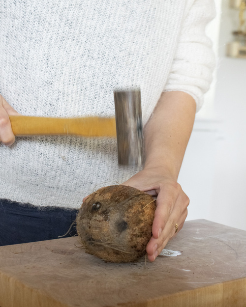 Kokosnuss mit Hammer bearbeiten