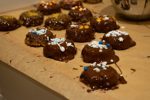 KI generiert: Schokoladenüberzogene Plätzchen mit bunten Streuseln auf Backpapier.