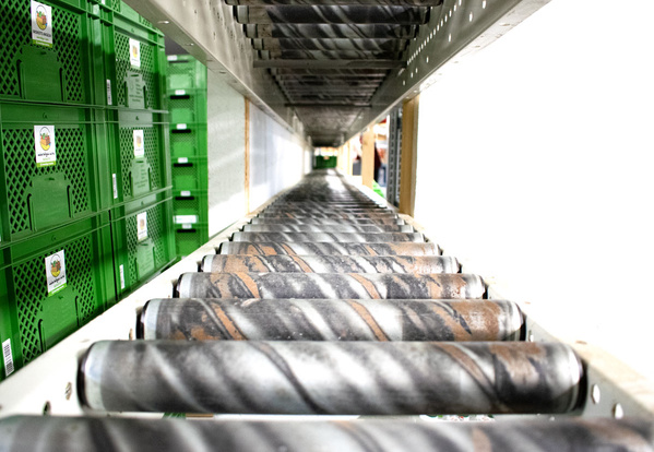 KI generiert: Förderband mit grünen Kisten an der Seite in Lagerumgebung.