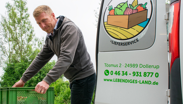 Christian lädt gerade Kisten in den Lieferwagen vom Lebendigen Land