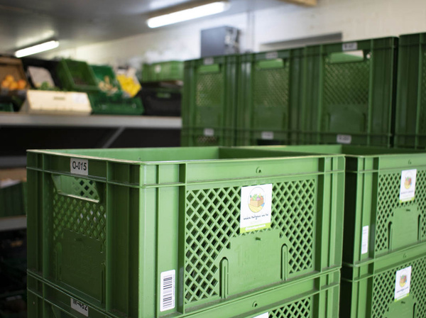 KI generiert: Grüne Kisten im Lager; Aufschrift auf Kisten: "www.bioland-weiling.de".