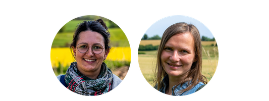 KI generiert: Zwei Personen lächeln in die Kamera, im Hintergrund sind Felder zu sehen.