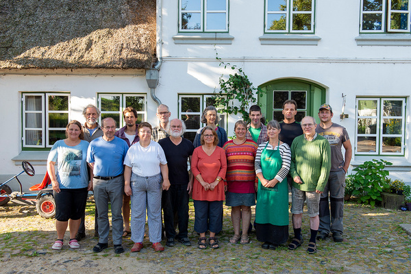 KI generiert: Eine Gruppe von Menschen steht vor einem Gebäude und posiert für ein Foto.