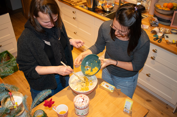 KI generiert: Zwei Personen backen zusammen in einer Küche und mischen Zutaten in einer Schüssel.
