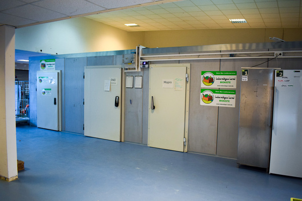 KI generiert: Ein Lagerraum mit großen Kühltüren und Schildern der „BIOT.ISTE“.