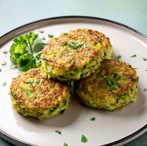 KI generiert: Drei gebratene Gemüsepuffer auf einem Teller mit Petersilien-Dekoration.