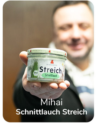 KI generiert: Mann hält ein Glas "Schnittlauch Streich" in der Hand. Text: "Mihai Schnittlauch Streich".