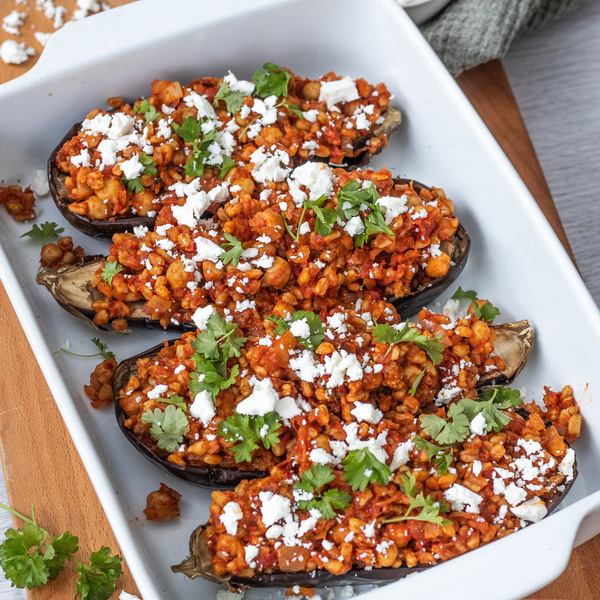 KI generiert: Gefüllte Auberginen mit Tomaten, Kräutern und Feta in einer weißen Auflaufform.