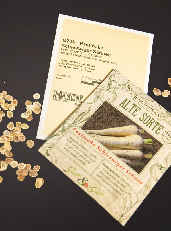 KI generiert: Samentütchen von Pastinake 'Schleswiger Schnee' mit Samen daneben. Text enthält Pflanzanleitung und Eigenschaften.