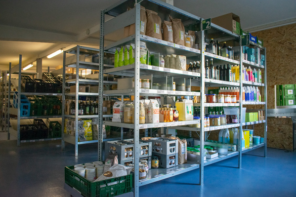 KI generiert: Regale mit verschiedenen Produkten, darunter Reinigungsmittel und Lebensmittel, in einem Lagerraum.