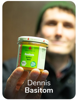 KI generiert: Eine Person hält ein Glas "Basitom" von Zwergenwiese; Text: "Dennis Basitom".