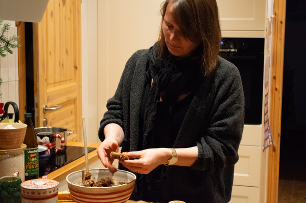KI generiert: Eine Person formt in der Küche Teig aus einer Schüssel. Text: "HYGGE PUNSCH".