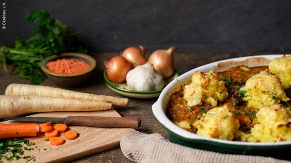 KI generiert: Herbstliches Gemüsegericht mit Pastinaken, Karotten und Zwiebeln, dekoriert mit Kräutern.