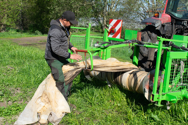 KI generiert: Ein Mann arbeitet auf einem Feld mit einer landwirtschaftlichen Maschine.