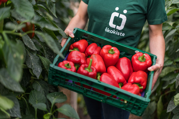 Frau mit Paprikakiste